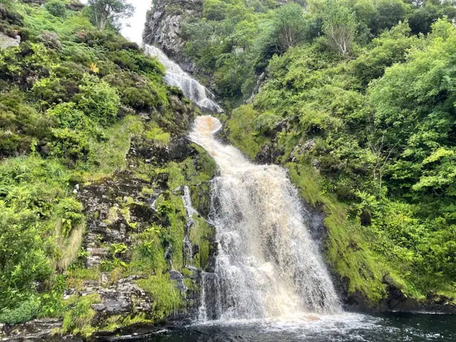 A waterfall cascading down a green Irish hillside