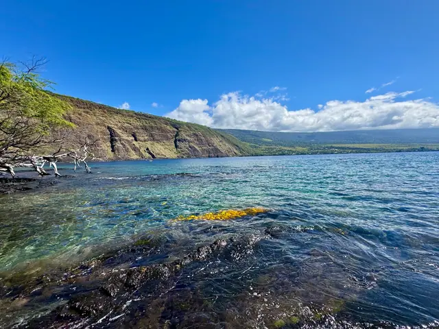 A calm turquoise Hawaiian bay ringed by green cliffs