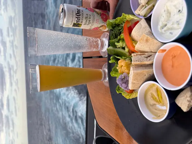 A lunch platter and drinks on a boat with the ocean wake trailing behind